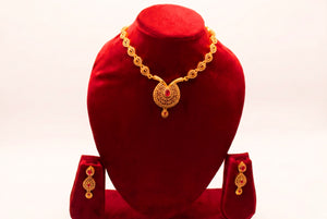 Gold necklace of pave teardrop links with granule dome pendant and ruby teardrop, with matching earrings