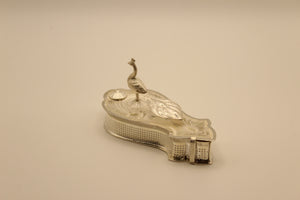 Silver paisley-shaped haldi kumkum container with sculpted peacock on the engraved lid